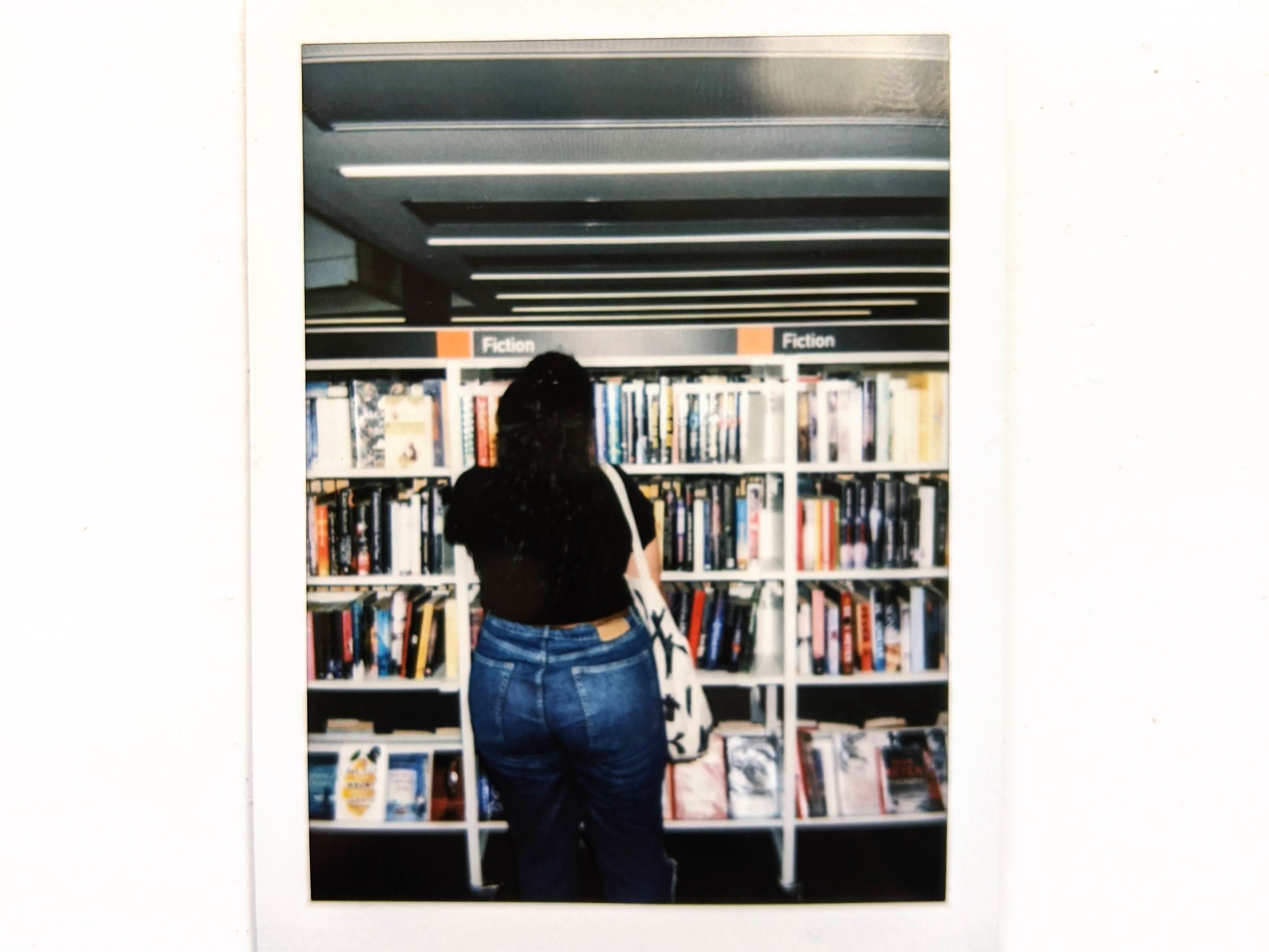 A picture of the author of the blog against bookshelves