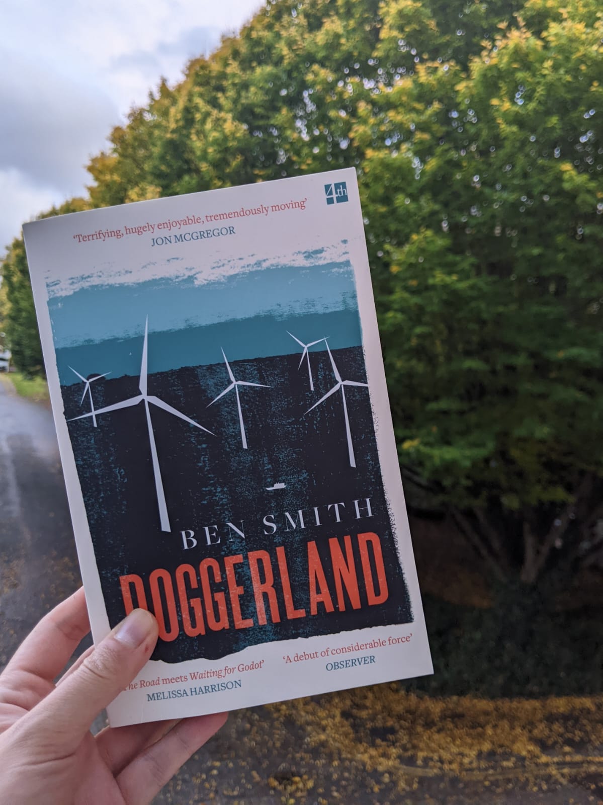 A picture of the book Doggerland against a tree with a moody atmosphere