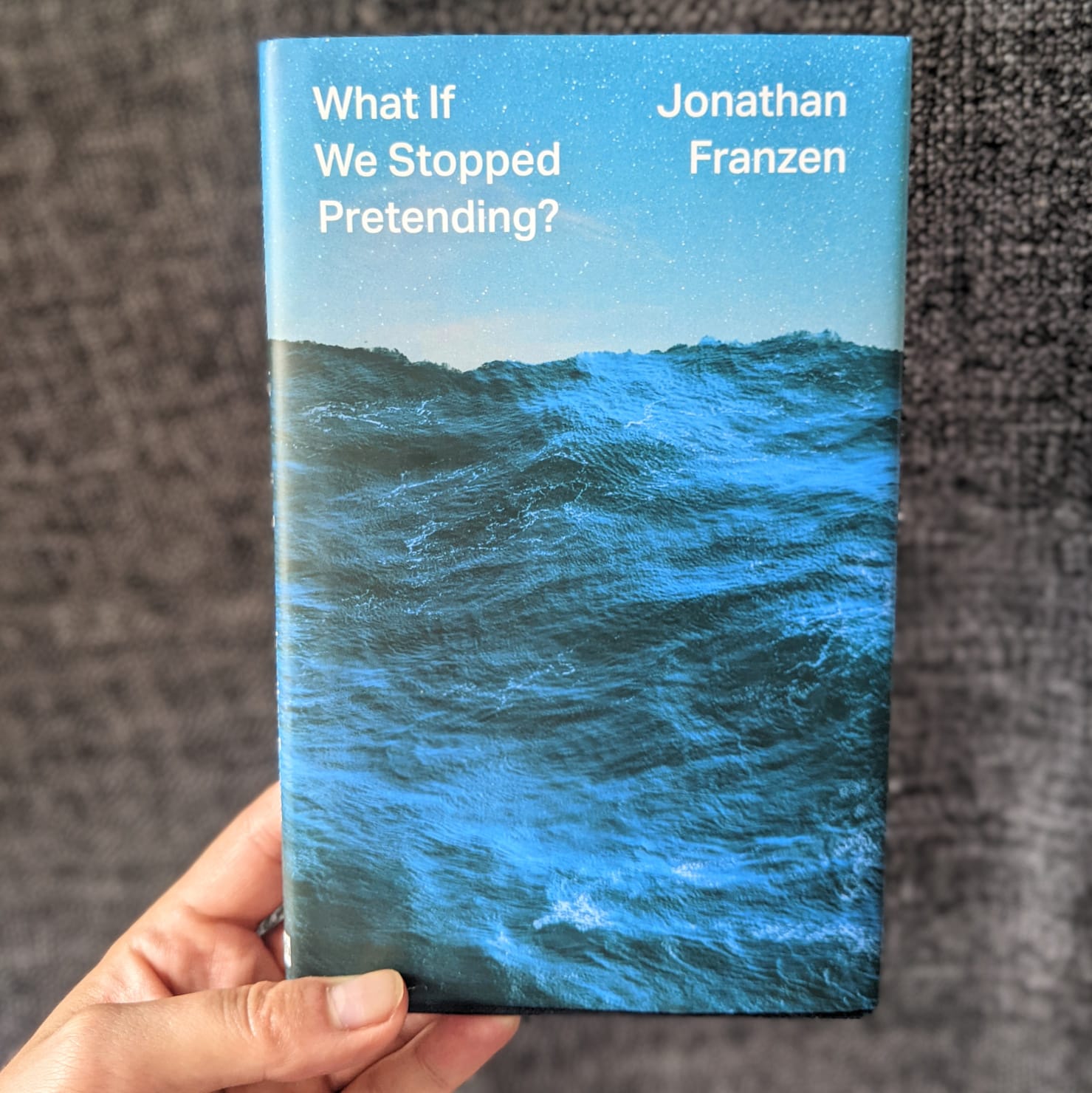 A picture of a copy of What If against a backdrop of palm leaves indoors